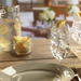 Glass of water with ice cubes and lemon on a wooden table in a restaurant setting.
